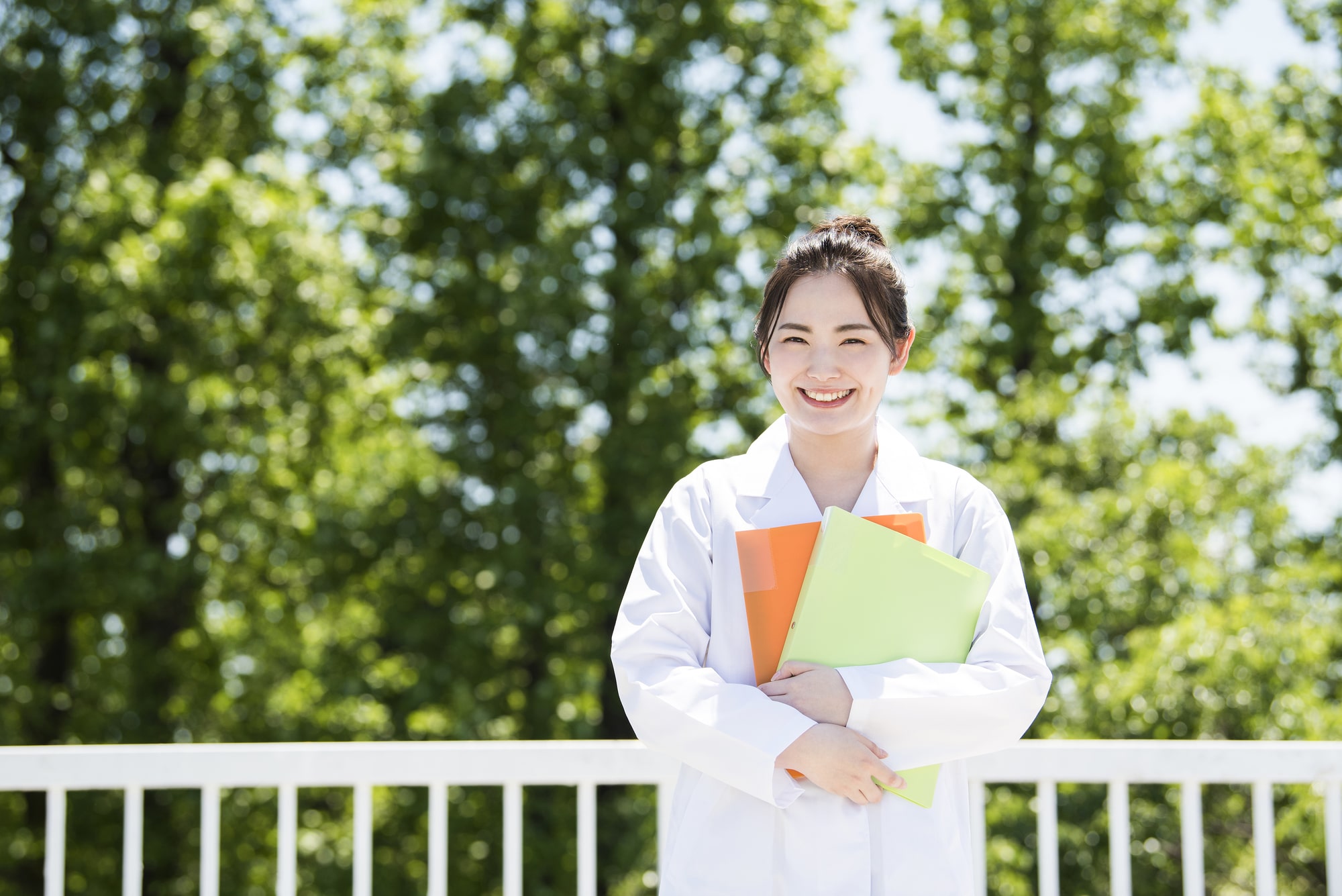 ファイルを抱える白衣の女性