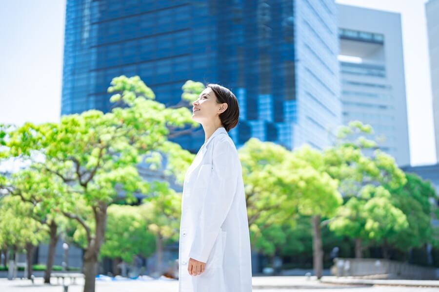 空を見上げる白衣の女性